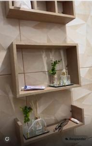 a wooden shelf with plants and other items on it at Aconchegante demais in Macapá