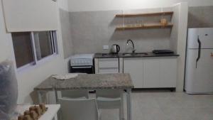 a small kitchen with a table and a refrigerator at Nebel Apart in Concordia