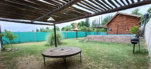 a patio with a wooden table and a wooden house at Cabañas Rústicas Entre Montañas in Tunuyán +4 photos