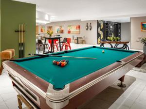 a pool table in a living room with a pool at ibis Jeddah City Center in Jeddah