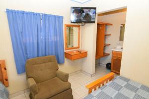 a living room with a chair and a mirror at San Felipe Rental Studio #1 Free WiFi and Cable TV in San Felipe