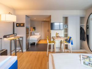 a small apartment with a bed and a kitchen and a bedroom at Aparthotel Adagio Access Freiburg in Freiburg im Breisgau