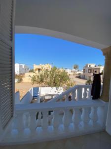 un balcon blanc avec vue sur la plage dans l'établissement Afif Apartment Djerba, à Al Maqārisah 2 autres photos