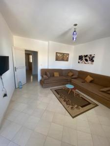 un salon avec un canapé et une télévision dans l'établissement Afif Apartment Djerba, à Al Maqārisah