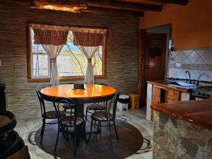a kitchen with a table and chairs in a room at Ensueño del alma in Villa Pehuenia