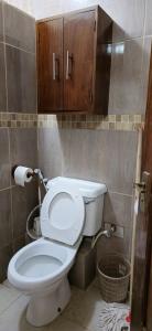 a bathroom with a white toilet and a cabinet at Diani Airport View Apartments in Diani Beach