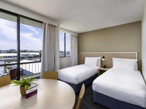 a hotel room with two beds and a balcony at Mercure Rockhampton in Rockhampton +64 photos