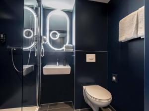 um banheiro com vaso sanitário e pia em ibis Duesseldorf Airport em Düsseldorf mais 22 fotografias