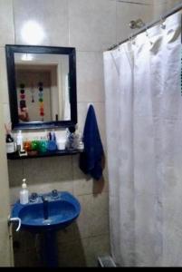 een badkamer met een wit douchegordijn en een blauwe wastafel bij Amy in La Plata +30 foto's