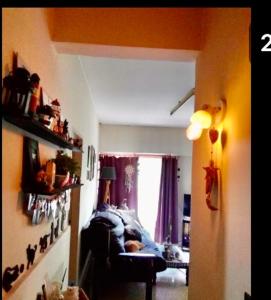 een woonkamer met een bank en een raam bij Amy in La Plata