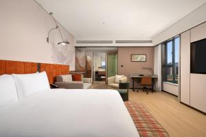 a hotel room with a bed and a living room at Hilton Garden Inn Lanzhou Anning in Lanzhou +45 photos