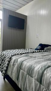 ein Schlafzimmer mit einem Bett und einem Fernseher an der Wand in der Unterkunft Premium Black 2 in Canela