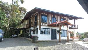 una casa con un gatto in piedi di fronte di Casa Campestre La Montaña a Filandia