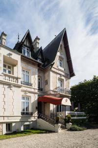 a large white building with a black roof at Villa 81 in Deauville +50 photos