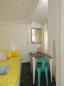 a small room with a table and a green chair at Suan's Nook Guest House in Larena
