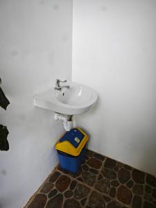 a bathroom with a sink and a trash can at Suan's Nook Guest House in Larena