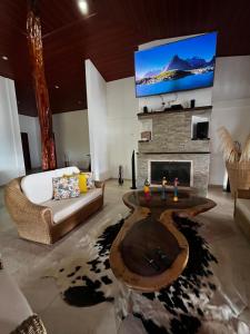 a living room with a fireplace and a tv at Villa Celeste in Macanal