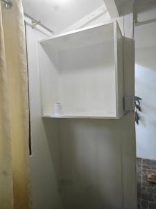 a white cabinet on a wall in a bathroom at Suan's Nook Guest House in Larena