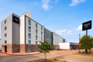a hotel building with a sign in front of it at voco College Station Aggieland by IHG in College Station