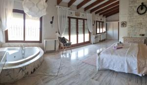 1 dormitorio con bañera, 1 cama y 1 silla en Gold Valentia El Nido, en Fanadix