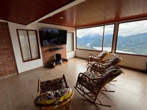 a living room with chairs and a flat screen tv at Villa Celeste in Macanal