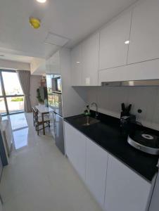 a kitchen with white cabinets and a black counter top at Cozy 1-BR Condo Unit in Mandaue City +12 photos