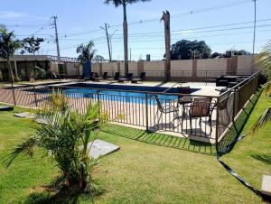 a fence around a swimming pool in a yard at Apartamento aconchegante in Maringá