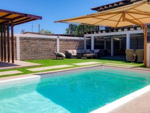a swimming pool in a yard with an umbrella at Casa Barquito - Pool house in San Felipe in San Felipe