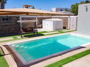 a swimming pool with a chair and an umbrella at Casa Barquito - Pool house in San Felipe in San Felipe +21 photos