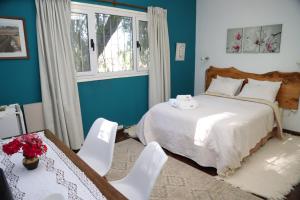 a bedroom with a bed and two white chairs at Escapada Exclusiva en Finca con Viñedos y Olivares Relájate en la Naturaleza con Confort y Encanto in San Rafael