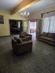 een woonkamer met 2 banken en een kroonluchter bij Hotel Nuevo Molino in Huerta Grande +7 foto's