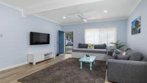 een woonkamer met een bank en een tv bij 30 Curlew Avenue Hawks Nest in Hawks Nest