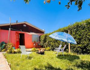 科布克库拉Casa Costa Ñuble的草屋,有两把椅子和一把伞