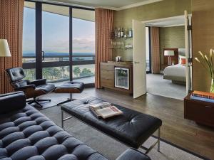 a living room with a couch and a large window at Fairmont Miramar Hotel & Bungalows in Los Angeles