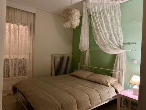 a bedroom with a bed with a canopy and a window at Roseberry luxury apartment in Tríkala