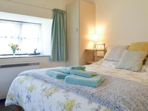 a bedroom with a bed with blue towels on it at Ramscliff Cottage in Cheddar +5 photos