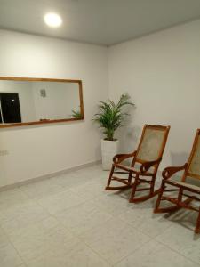 two rocking chairs in a room with a mirror at Casa Isabel in Santa Cruz de Mompox