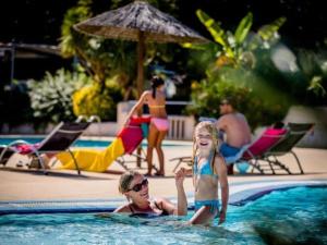 a man and a little girl in a swimming pool at Chalet 6 pers, 2 ch, Terrasse, Équipements Bébé - API-1-52-708 in Sainte-Eulalie-en-Born