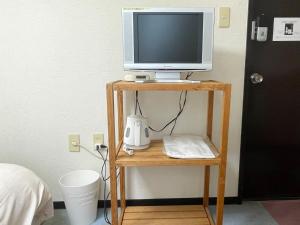 a tv on a wooden stand with a monitor on it at Rakuda Hotel Jinguu - Vacation STAY 97183v in Miyazaki