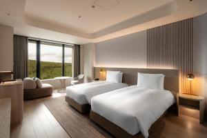 a bedroom with two beds and a large window at Chalet Ivy Weiss, Niseko in Kutchan