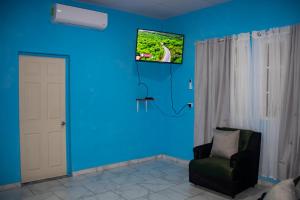 a room with a blue wall with a chair and a tv at Coco Cabana en Playa San Diego in San Diego