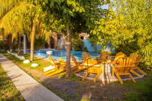 a group of wooden tables and chairs under a tree at Coco Cabana en Playa San Diego in San Diego
