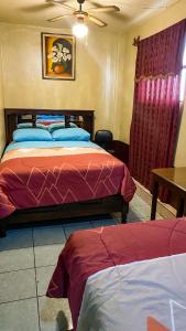 グアテマラシティにあるHotel Landivar Zona 7のベッド2台とテーブルのある寝室