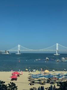 Blick auf einen Strand mit einer Brücke im Hintergrund in der Unterkunft NEW Gwangalli Beach 3-minute walk in Millak-tong