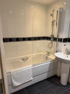 a bathroom with a bath tub and a sink at Olive Den in Wolverhampton