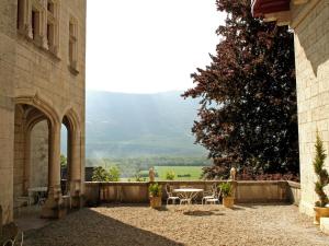 a patio with a table and chairs and a tree at Apartment near French Alps in Serrières-en-Chautagne