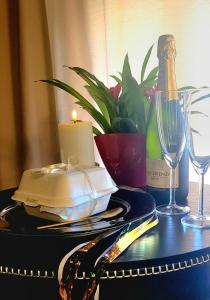 a table with a candle and a bottle of wine at Apartament Plac Zabaw in Łódź +33 photos