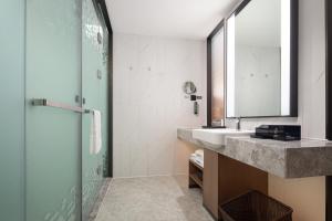 een badkamer met een wastafel en een spiegel bij Hampton by Hilton Hefei Binhu in Hefei