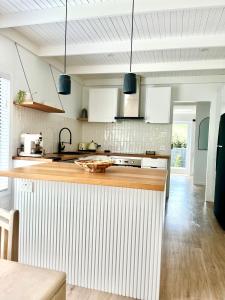 a kitchen with white cabinets and a wooden counter top at Little Red Gate Urban Retreat in Kingston