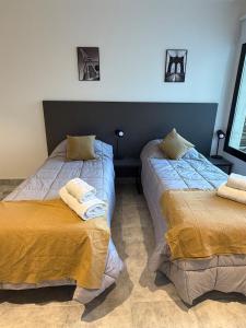 two beds sitting next to each other in a room at Departamento excelente ubicación in Comodoro Rivadavia